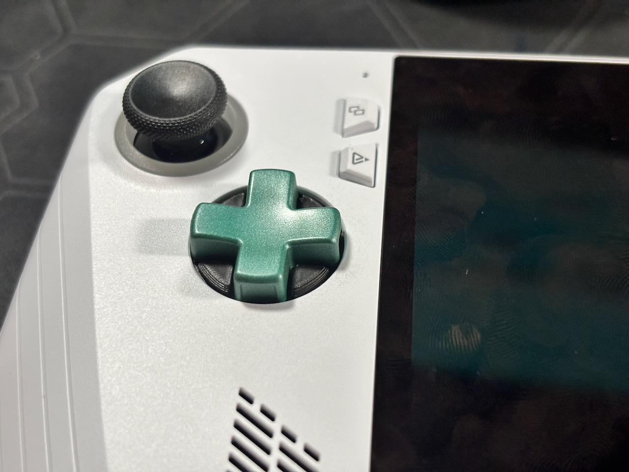 A close up photo of a metal green D-Pad on an Ally.